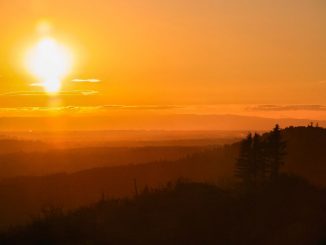 Phénomène lumineux dans le ciel (grand signe). Un soleil couchant qui ressemble à un ostensoir éclaire en rose le ciel et les montagnes environnantes.