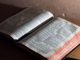 Bible ouverte sur une table brune. La page de droite est plus éclairée que celle de gauche.