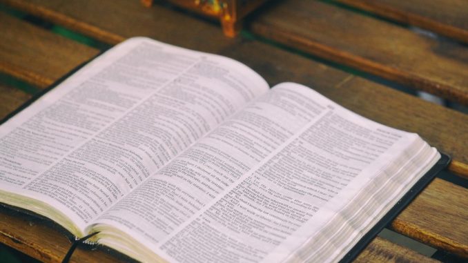 Bible ouverte sur une table en bois brun.