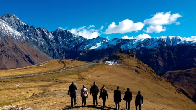 Groupe de personnes marchant dans les montagnes pendant la journée.