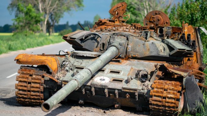Un char avec un canon sur une route de campagne durant le jour.