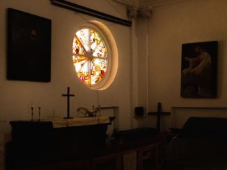 Croix noire sur un autel dans une petite chapelle.