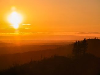 Luminous phenomenon in the sky (great sign). A settin g sun, that looks like a monstrance, lights up the sky and the surronding montains in pink.