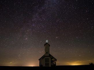 White chapel (call to holiness) under starry sky. Foreground in the dark and glow on the horizon in the background.