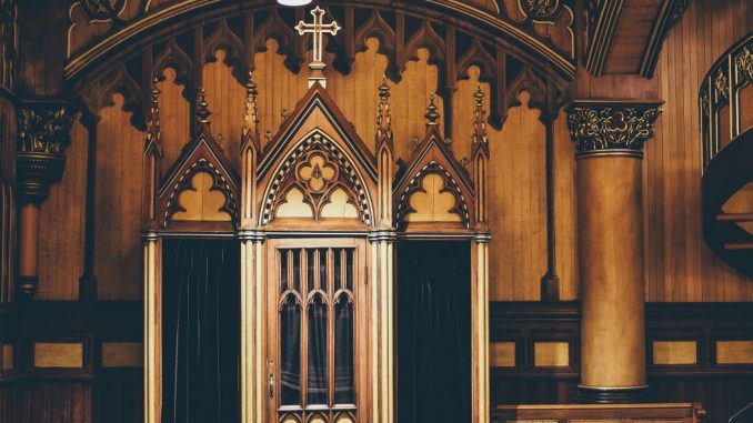 Confessional inside a cathedral. Brown and black wall behind.