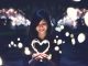 Woman holding a bright white heart in the evening. Very bright and blurry background.