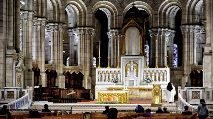 A few people praying inside the Sacré-Cœur Basilica.