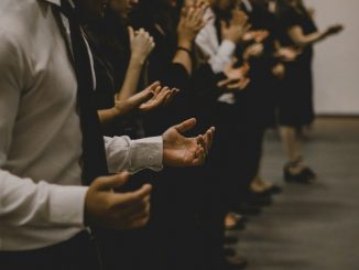 People praying inside a room. We can’t really see the faces.