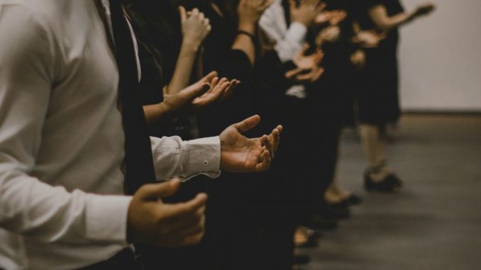 People praying inside a room. We can’t really see the faces.
