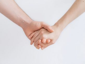 Woman and man holding hands. We only see the forearms and hands.