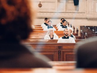 People praying, front views, sitting inside church building.