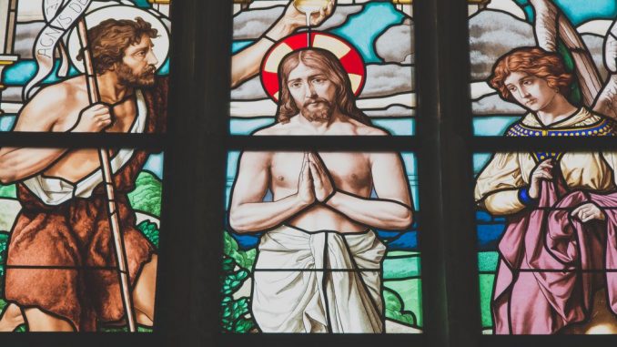 Religious stained glasss window showing the baptism of Jesus by John the Baptist.