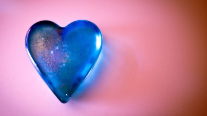Blue glass heart. Pink background.