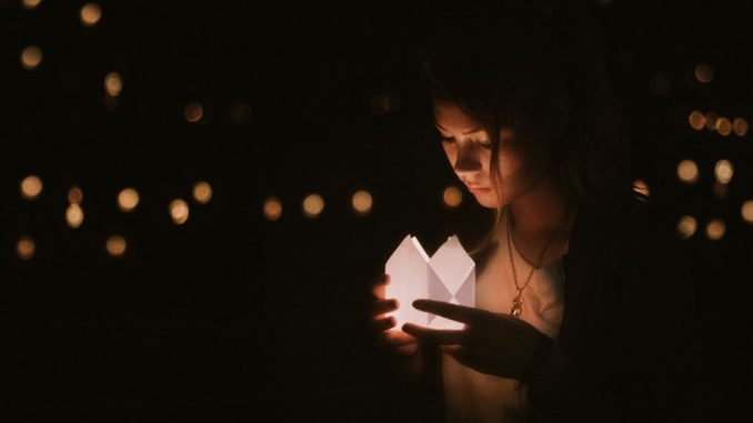 Bokeh photography of woman holding paper lantern.