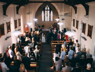 Wedding ceremony in a small church filled with guests.