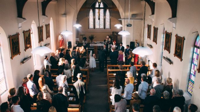 Wedding ceremony in a small church filled with guests.