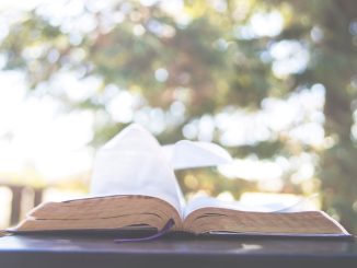 Open bible on table. Blurry image in the background.