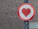 A red and white sign with a red heart in the center.